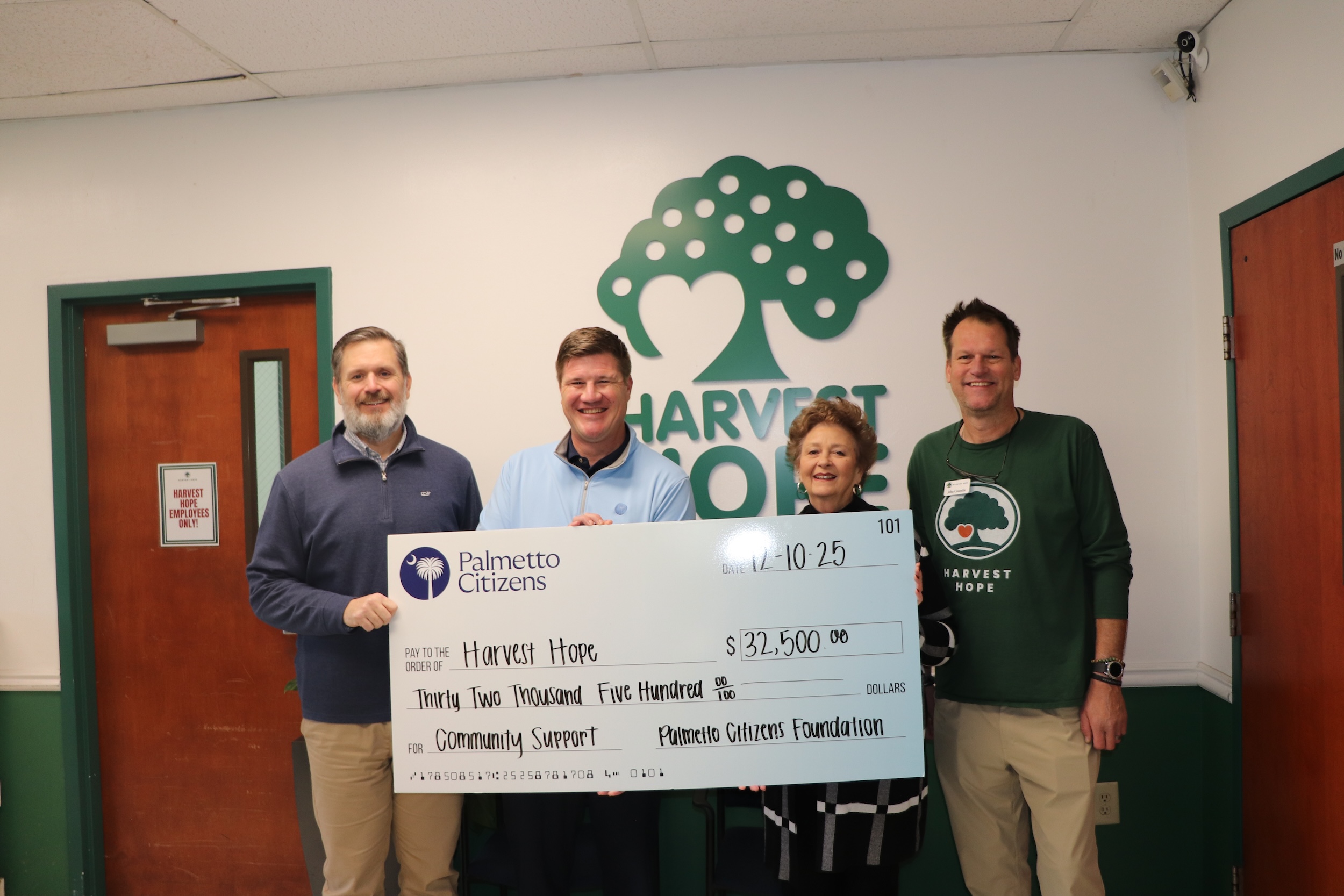 4 people holding large check titled "Harvest Hope"